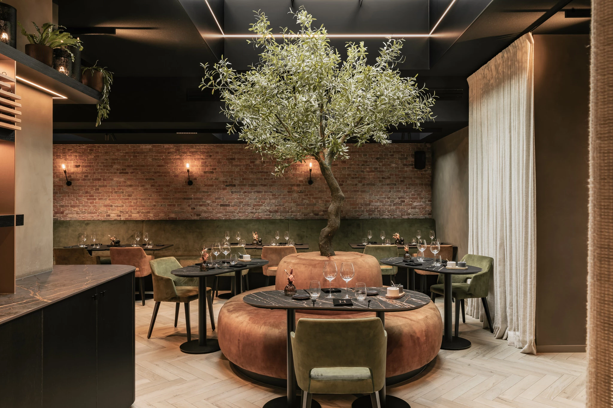 Zicht op boom en tafels errond in Restaurant Herenhuis Izegem