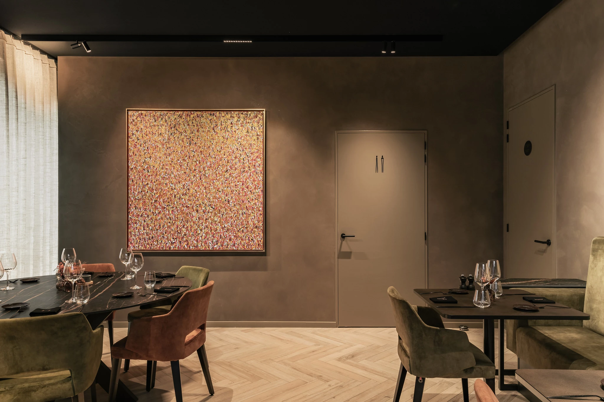 Zicht op "ziel van de wereld" schilderij aan ronde tafel in Restaurant Herenhuis Izegem