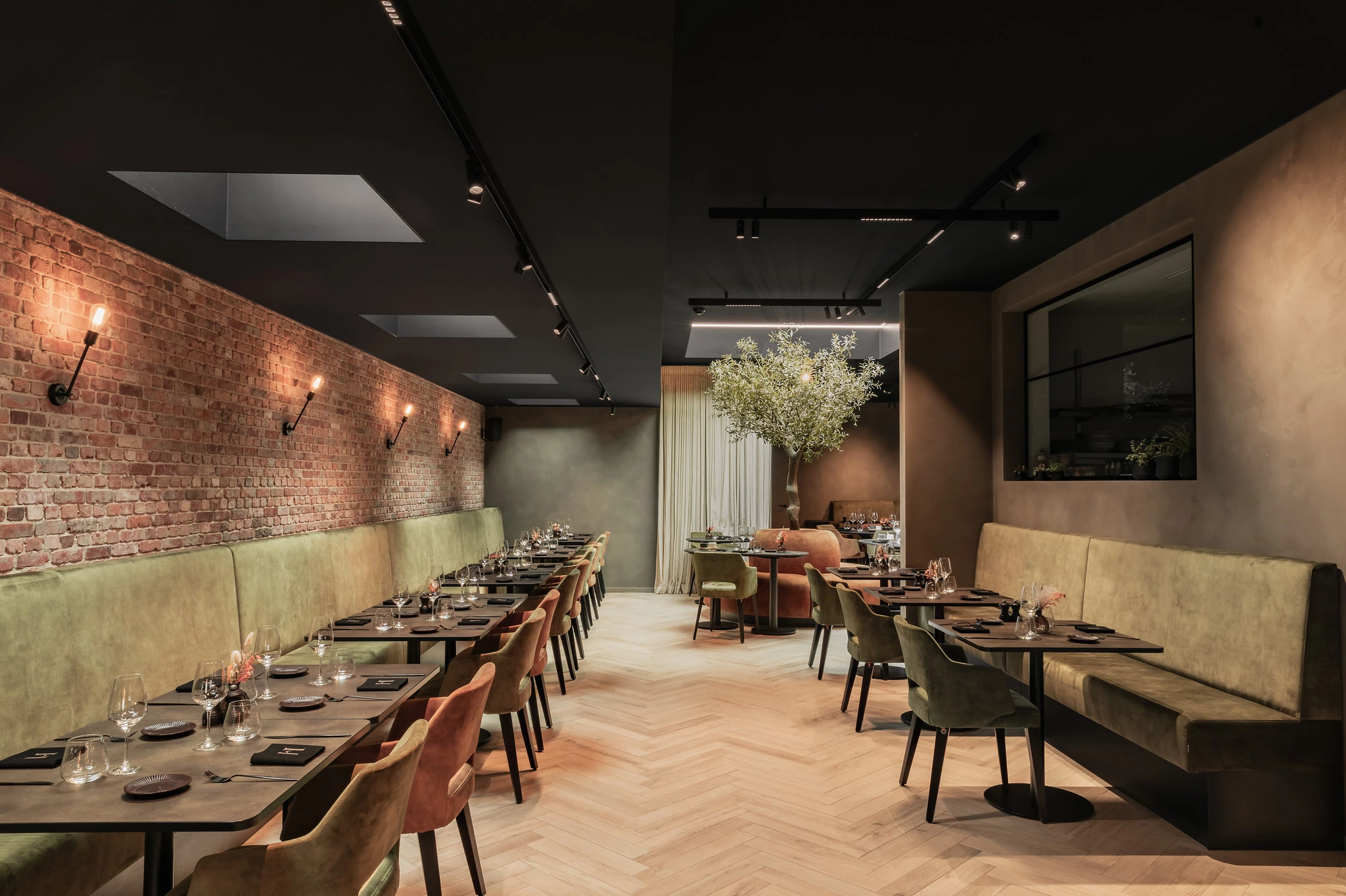 Tafels langs wand en gedeelte zetels aan keuken in Restaurant Herenhuis Izegem